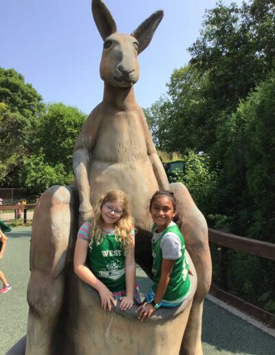 Two girl friends in a kangaroo statue pouch