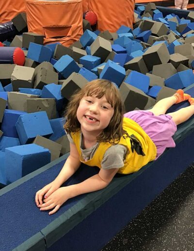 Girl posing in front of the foam play pit at Sky Zone