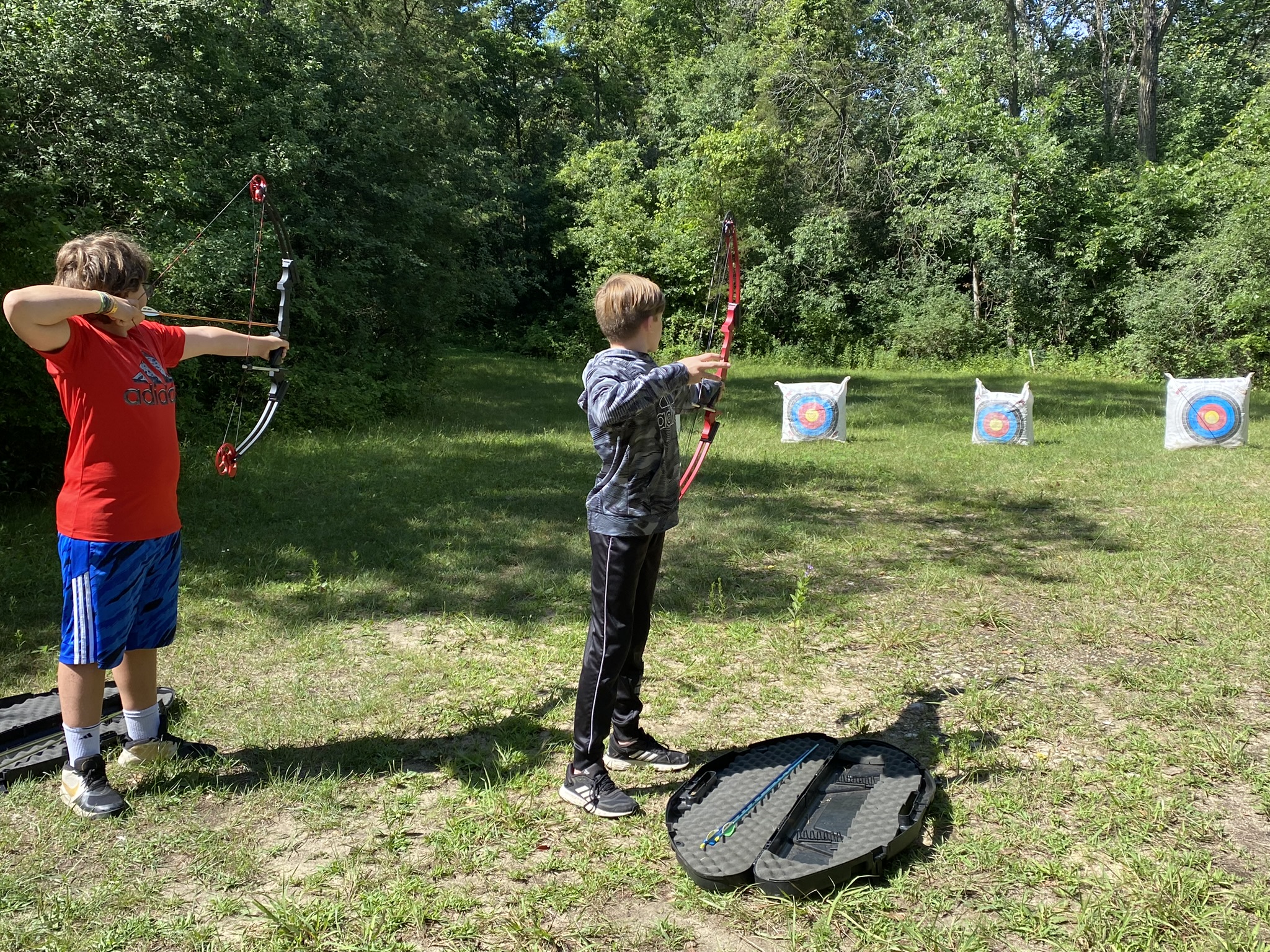 A picture of two boys practicing archery at Camp Carlson.